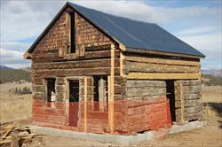 Snair  log cabin with safety fencing around front half of building